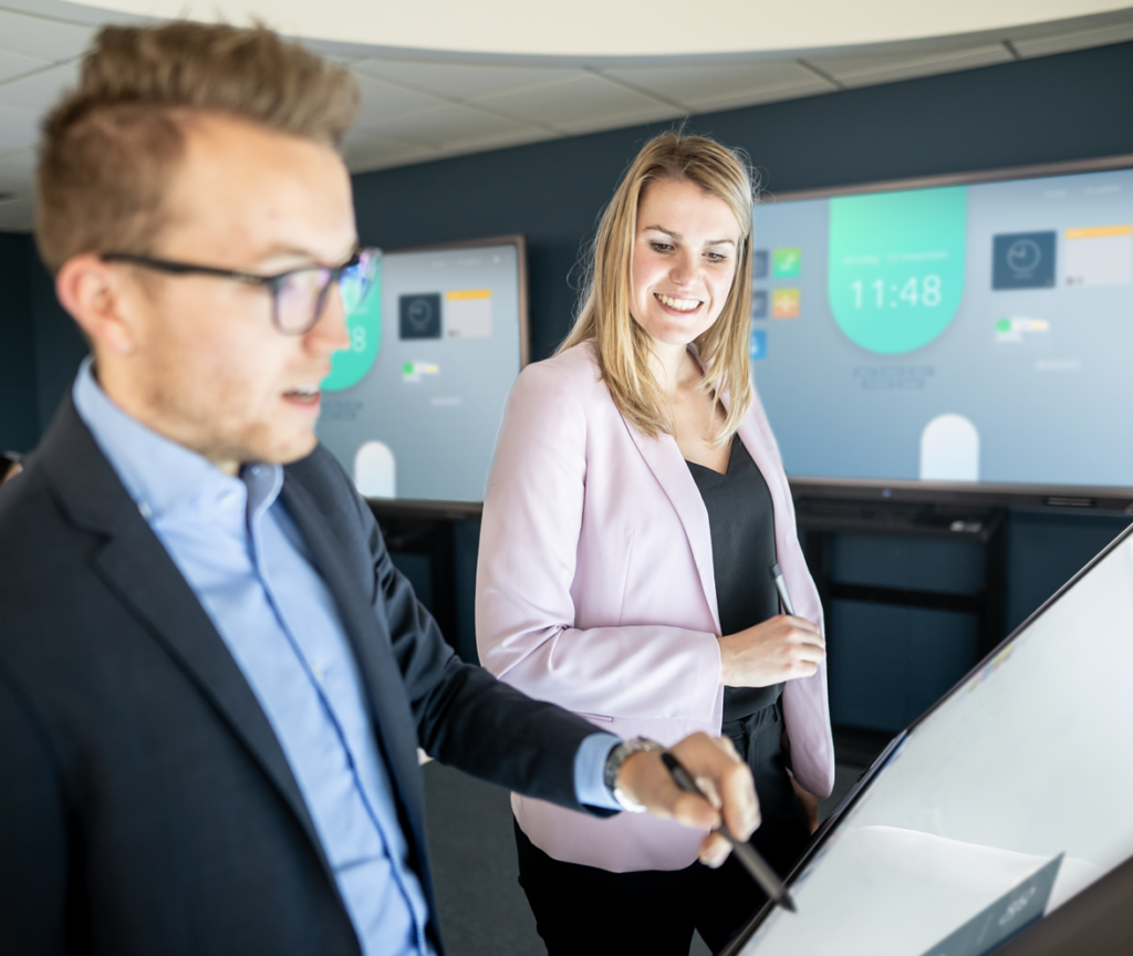 Twee leerkrachten werken met twee pennen tegelijk aan een Prowise touchscreen