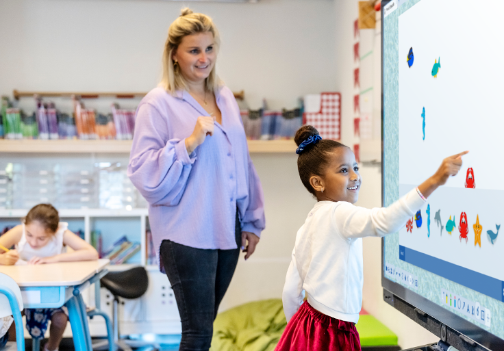 Teacher guides student playing game on Prowise touchscreen