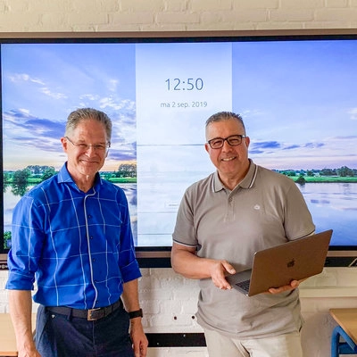 Die IKT-Mitarbeiter der De Globe Public Primary School stehen lächelnd vor dem Prowise-Touchscreen