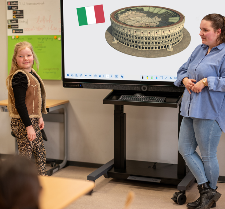 Meisje staat voor de klas met juffrouw terwijl ze gebruik maken van Prowise Presenter